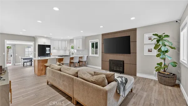 a living room with furniture a fireplace a flat screen tv and a potted plant