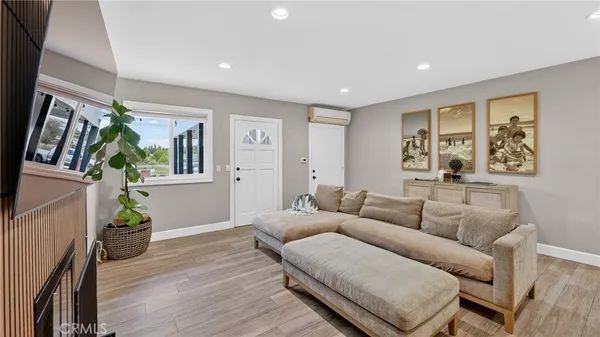 a living room with furniture a flat screen tv and a window