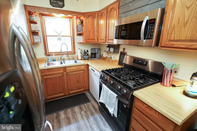 a kitchen with a stove a sink and a window