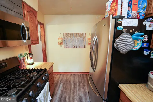 a view of a kitchen with fridge and wooden floor