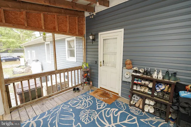 a view of a porch with wooden floor and furniture