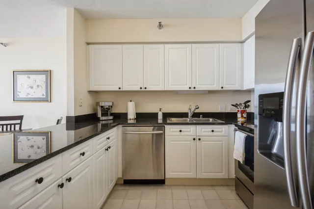 a kitchen with granite countertop white cabinets and stainless steel appliances