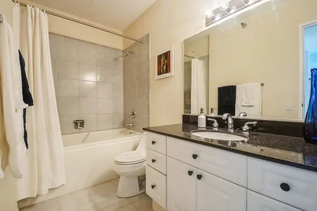 a bathroom with a granite countertop sink a toilet and shower