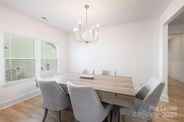 a large kitchen with white cabinets and chandelier