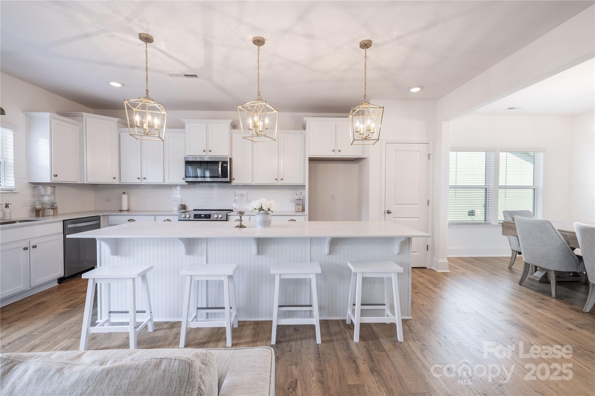 173 Tillery Lane Mount Gilead, NC 27306 - Photo 23 of 28 a large kitchen with white cabinets and chandelier