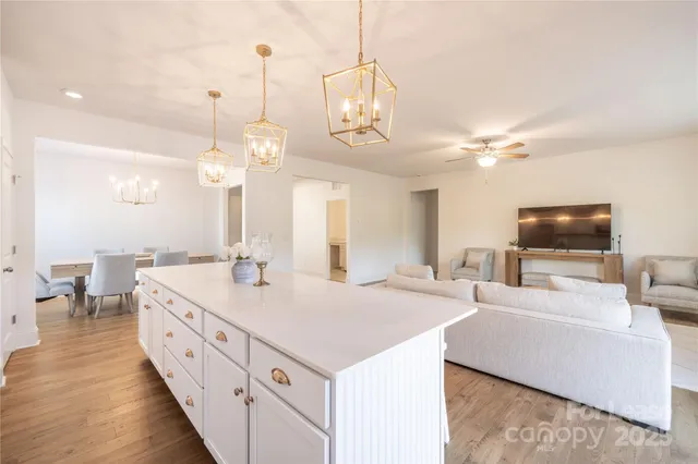 a large white kitchen with a large island in the center