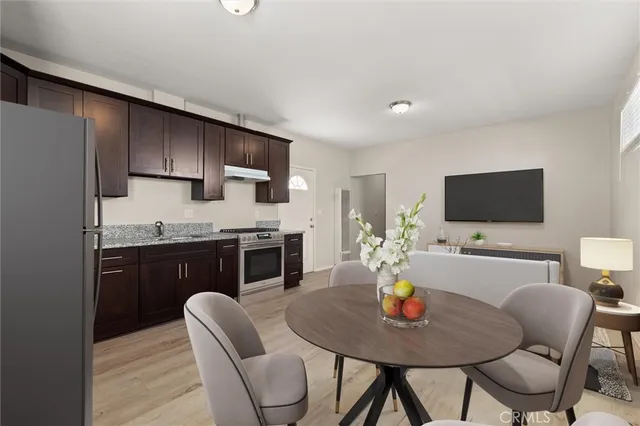 a kitchen with a stove a refrigerator and a dining table