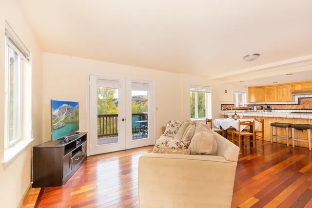 a living room with furniture and a flat screen tv with wooden floor