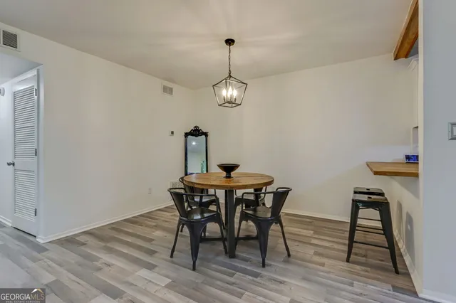 a view of a dining room with furniture wooden floor and a chandelier