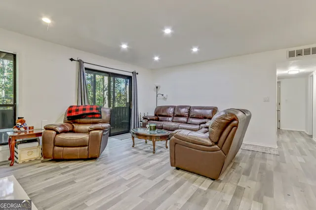 a living room with furniture window and a wooden floor