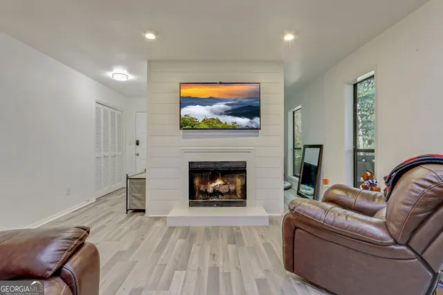a living room with furniture a fireplace and a flat screen tv