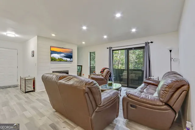 a living room with furniture a large window and a flat screen tv