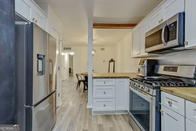 a kitchen with stainless steel appliances a stove microwave and cabinets