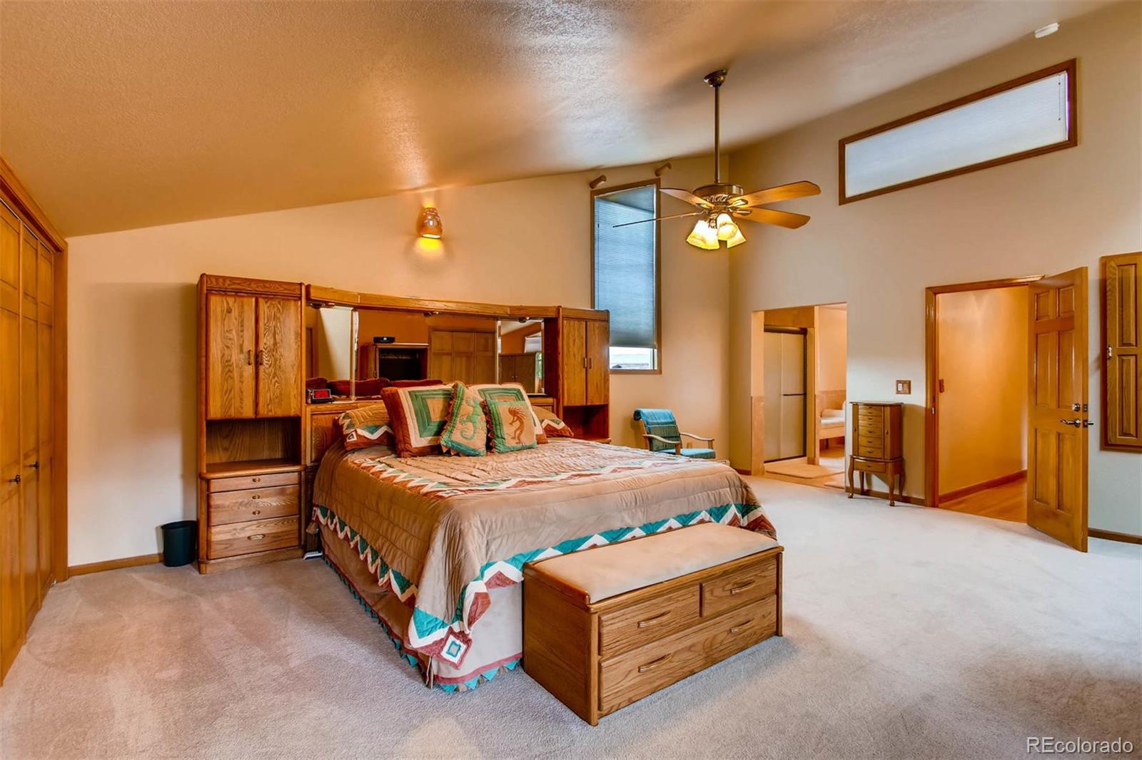 881 Valley Road Littleton, CO 80124 - Photo 16 of 27 a bed room with a bed and a chandelier