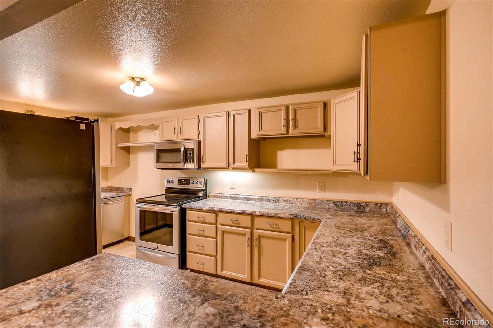 881 Valley Road Littleton, CO 80124 - Photo 26 of 27 a kitchen with stainless steel appliances granite countertop a stove top oven a sink and dishwasher