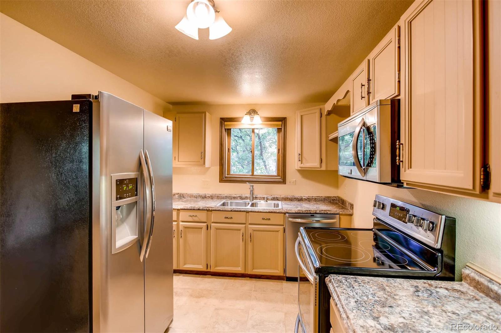 881 Valley Road Littleton, CO 80124 - Photo 27 of 27 a kitchen with stainless steel appliances granite countertop a refrigerator a stove and a sink