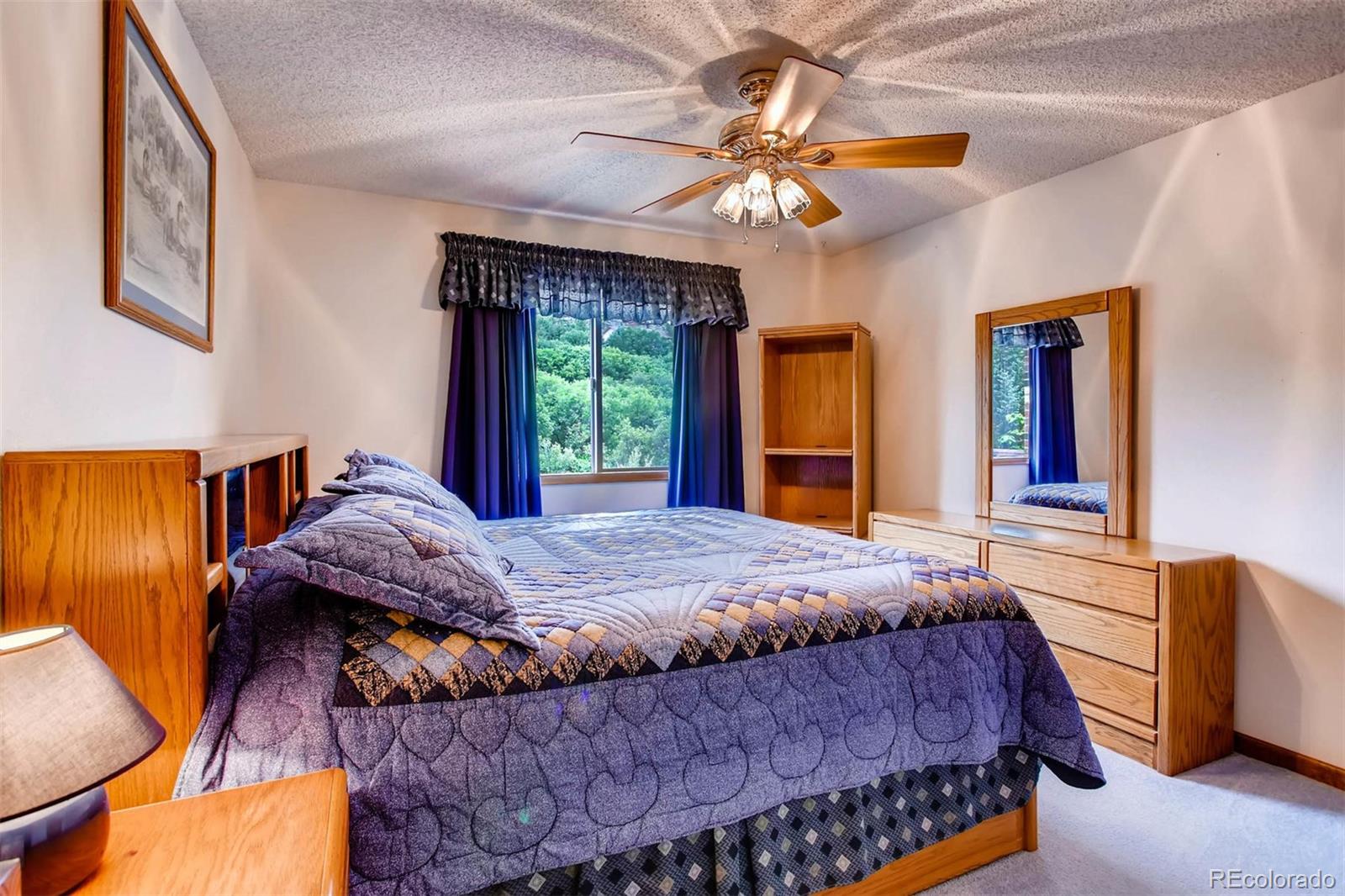 881 Valley Road Littleton, CO 80124 - Photo 8 of 27 a bedroom with a large bed and a chandelier