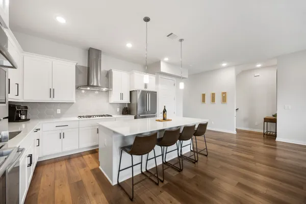 a living room with kitchen view and a refrigerator