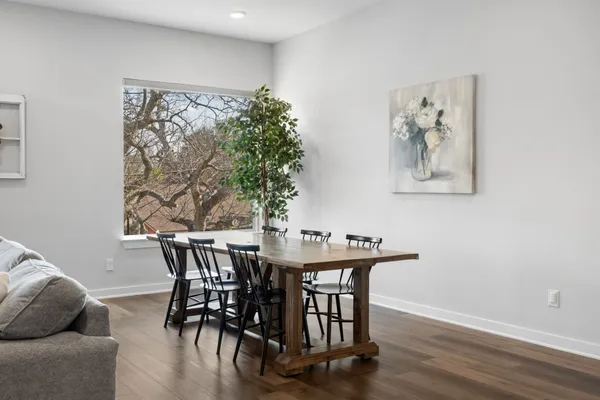 a kitchen with stainless steel appliances a dining table chairs stove refrigerator and cabinets