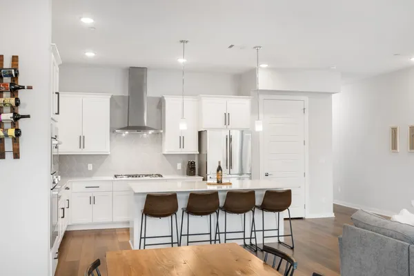 a large kitchen with kitchen island a stove a sink a center island and wooden floor