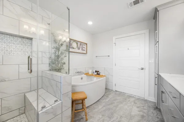 a spacious bedroom with a bed and a chandelier