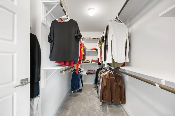 a spacious bedroom with a bed and a chandelier