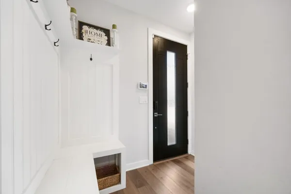 a view of an empty room with wooden floor and closet
