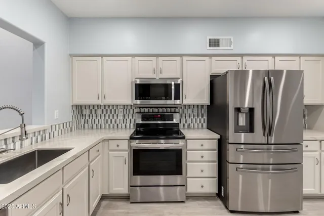 a kitchen with a refrigerator stove and sink