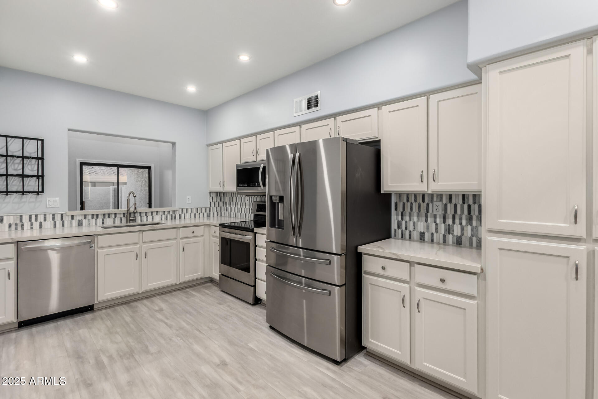 45 East 9th Place, Unit 80 Mesa, AZ 85201 - Photo 5 of 38 a kitchen with white cabinets and stainless steel appliances