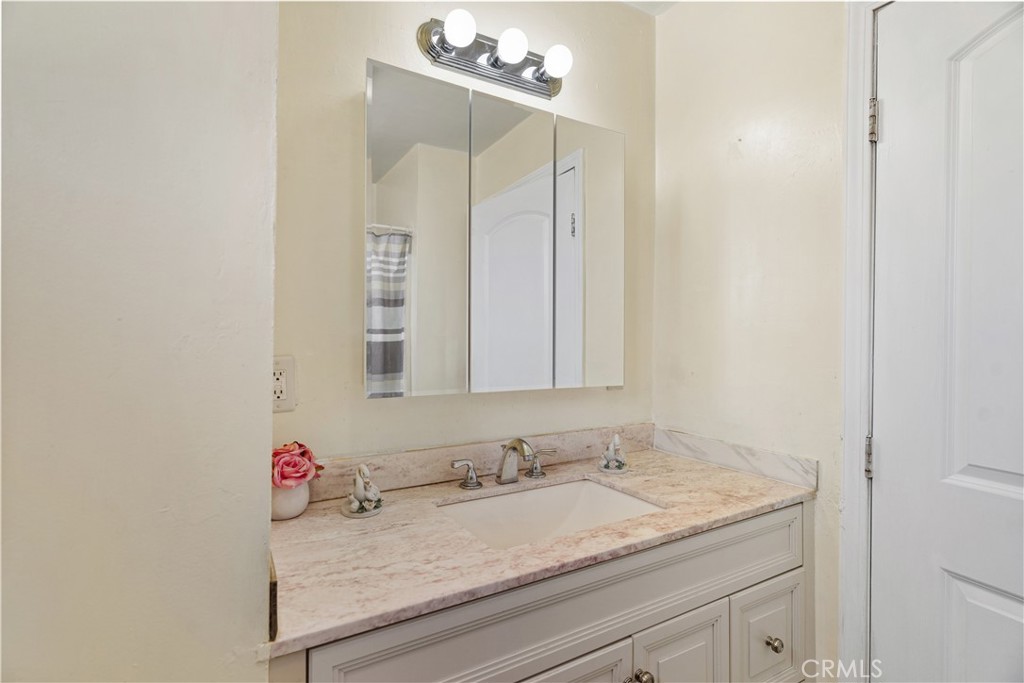 2113 Princeton Street Delano, CA 93215 - Photo 15 of 32 a bathroom with a granite countertop sink and a mirror