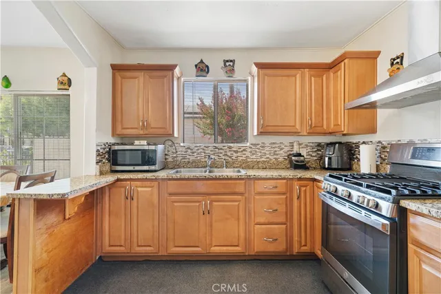 a kitchen with stainless steel appliances granite countertop a sink stove and cabinets