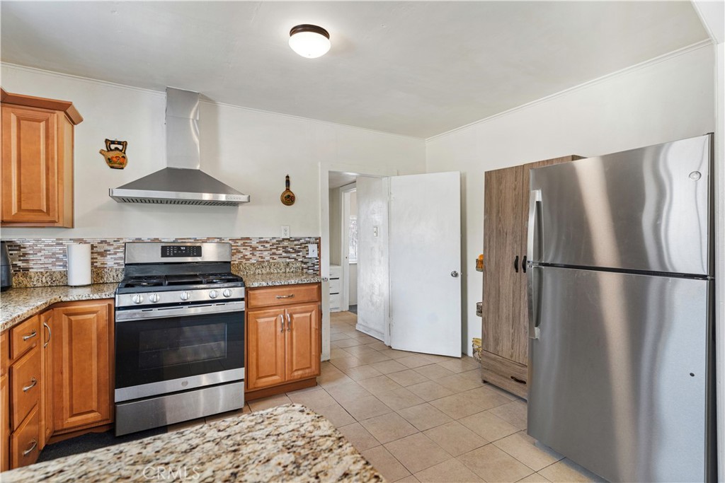 2113 Princeton Street Delano, CA 93215 - Photo 8 of 32 a kitchen with stainless steel appliances granite countertop a stove a refrigerator and a stove