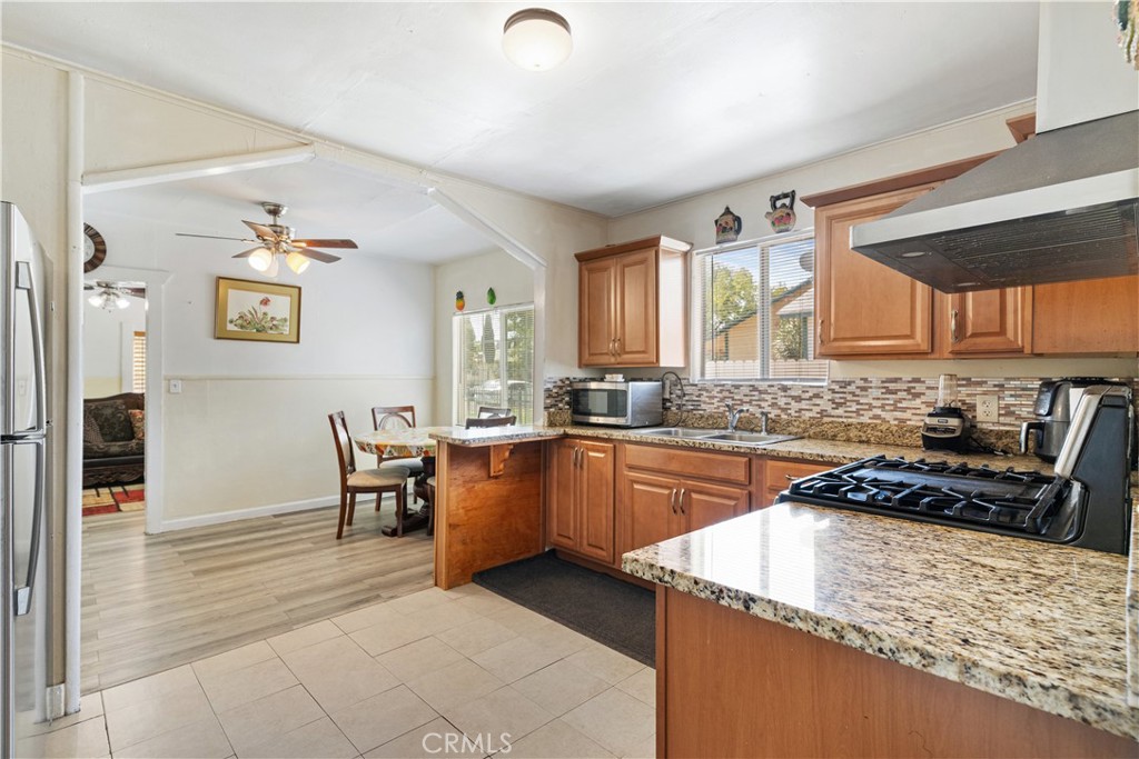 2113 Princeton Street Delano, CA 93215 - Photo 9 of 32 a kitchen with stainless steel appliances granite countertop a stove a sink and a refrigerator