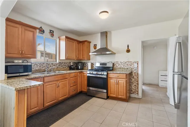 a kitchen with stainless steel appliances granite countertop a stove sink and cabinets