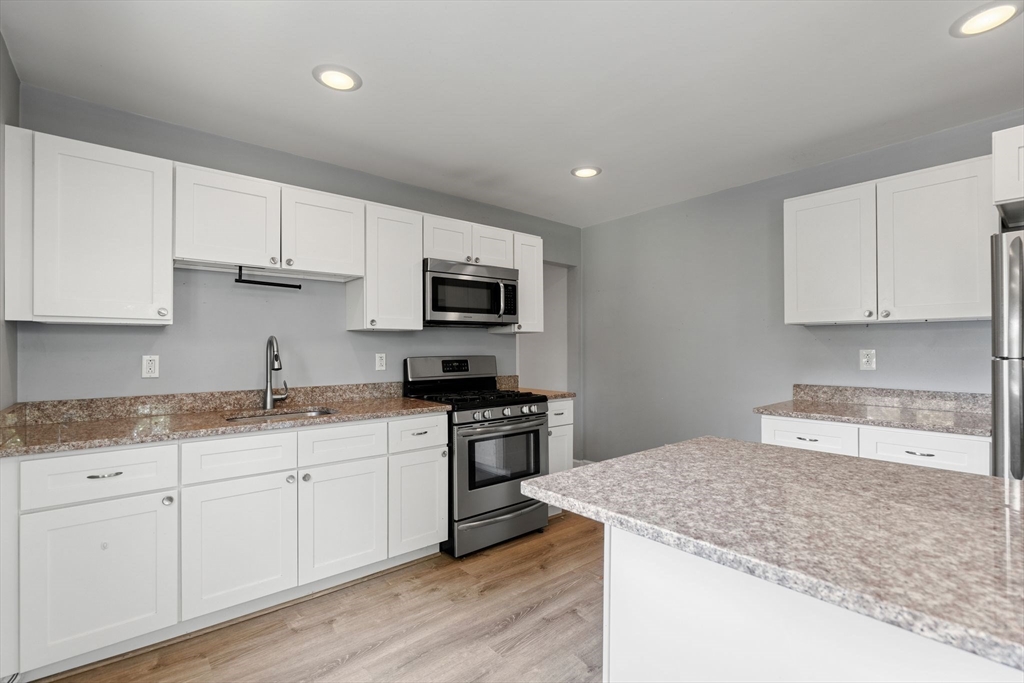 7 Carter Road Braintree, MA 02184 - Photo 21 of 42 a kitchen with granite countertop a sink stainless steel appliances and white cabinets