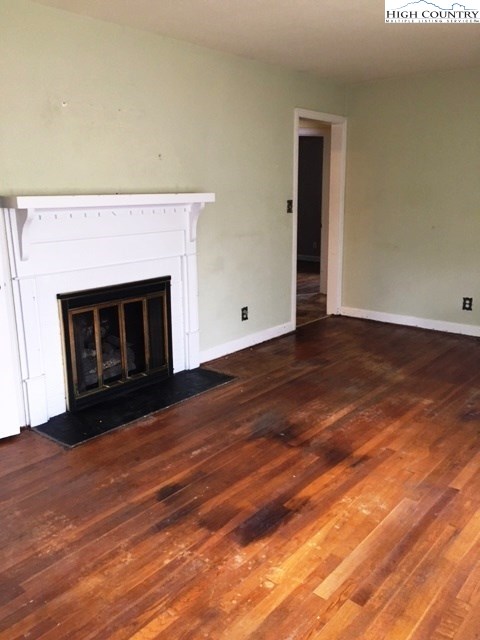 501 Oak Street Boone, NC 28607 - Photo 5 of 12 a view of empty room with wooden floor and fireplace