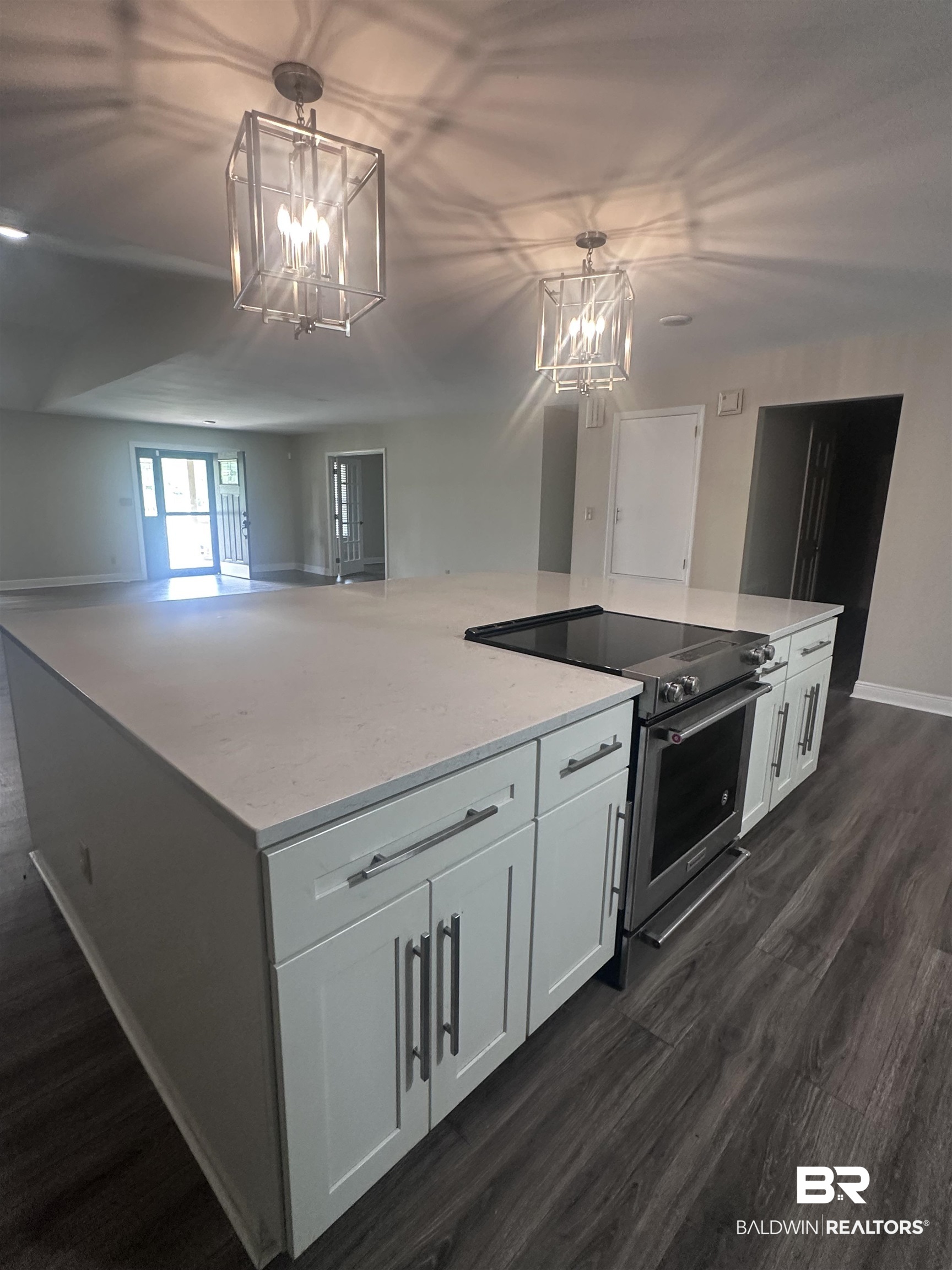 2785 Sowell Road Brewton, AL 36426 - Photo 15 of 24 Kitchen with stainless steel electric stove, a large island, dark wood-type flooring, white cabinets, and light stone countertops