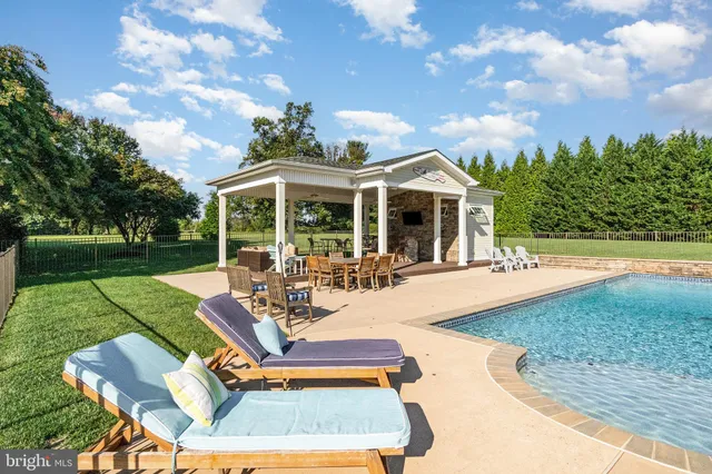 a view of a house with swimming pool and sitting area