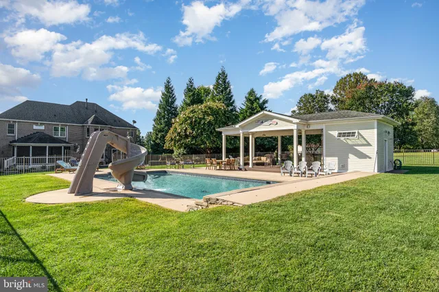 a view of a house with swimming pool and a yard