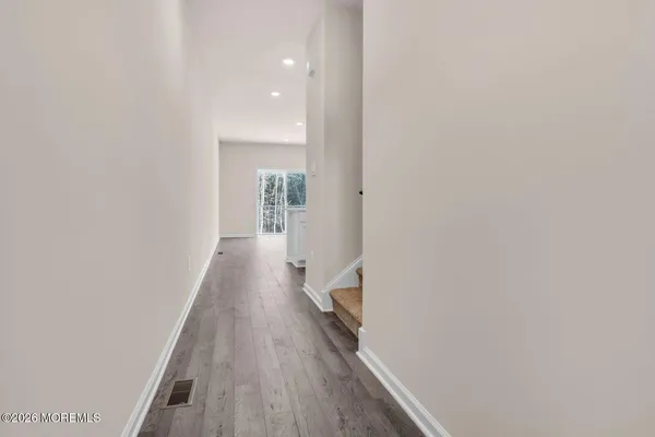 a view of a hallway with wooden floor