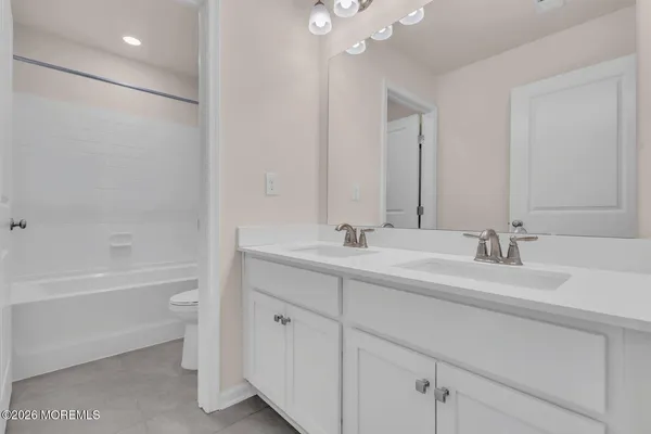 a bathroom with a double vanity sink mirror and a bathtub