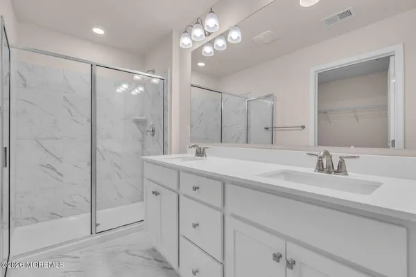 a bathroom with double vanity and a shower