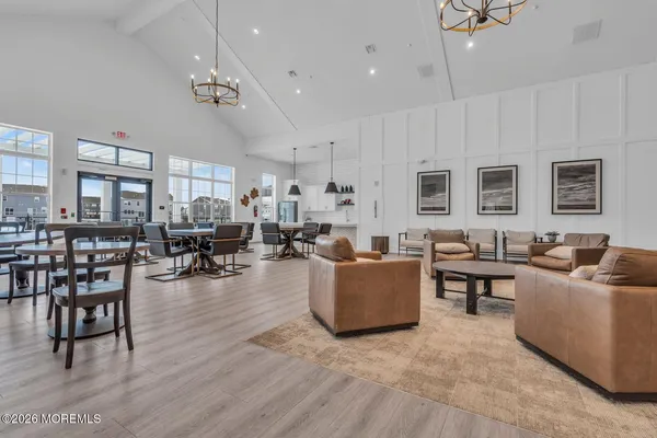 a living room with furniture kitchen view and a wooden floor