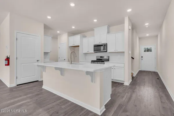 a kitchen with kitchen island white cabinets and refrigerator