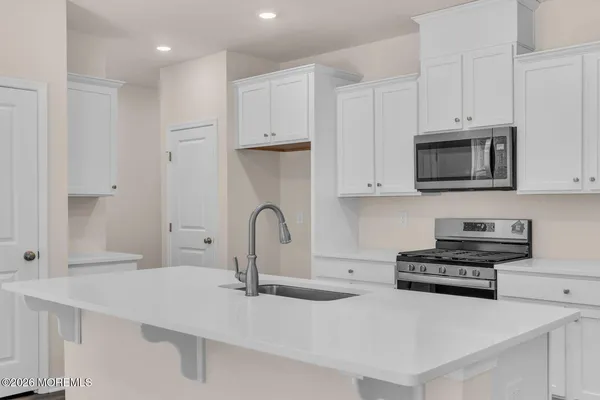 a kitchen with stainless steel appliances a sink a stove and a microwave