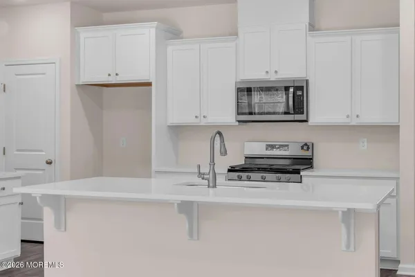 a kitchen with stainless steel appliances white cabinets and a sink