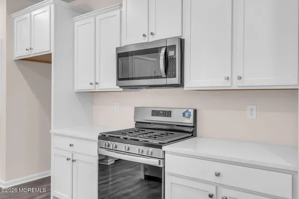 a kitchen with white cabinets and black appliances