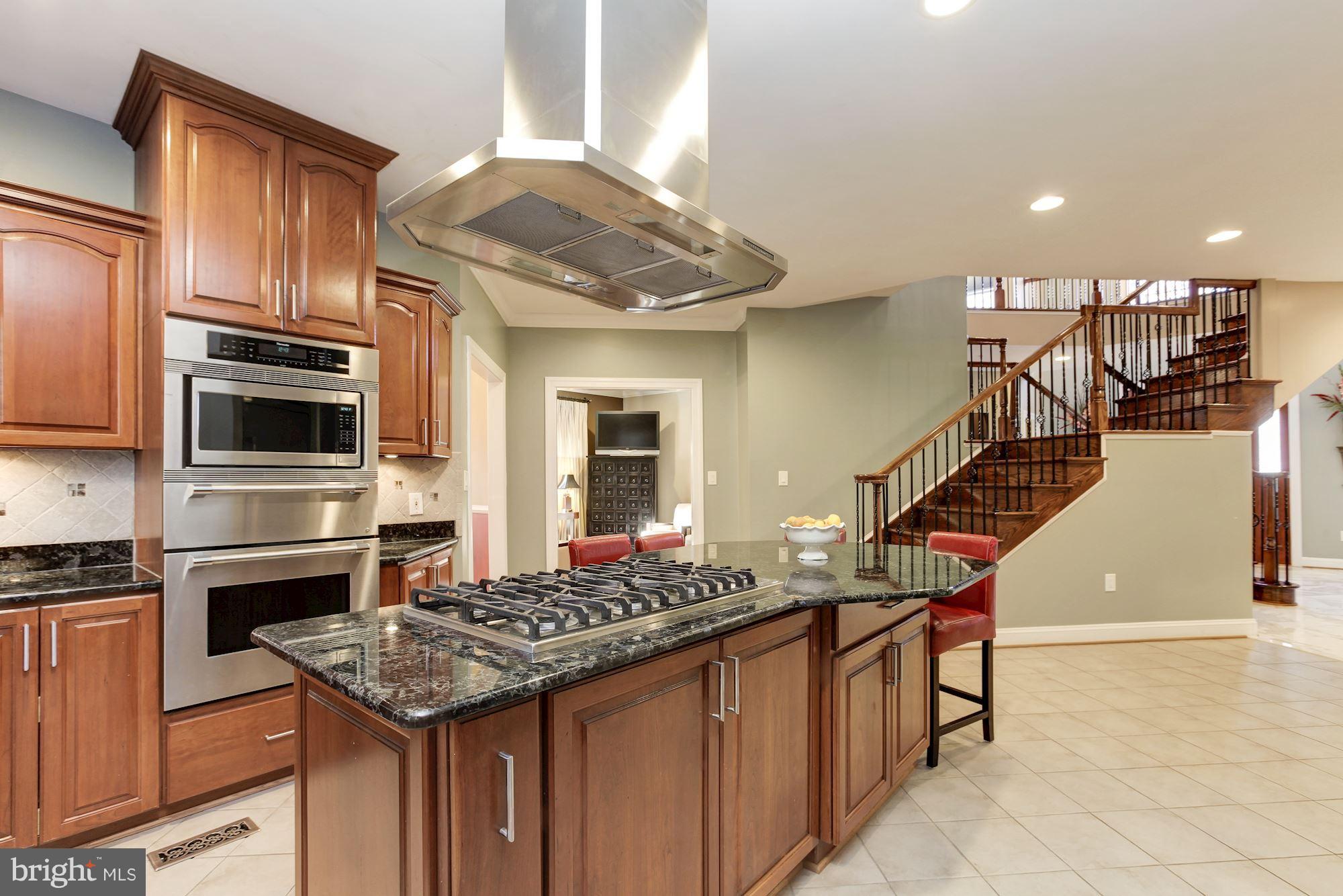 3406 Glorus Place Silver Spring, MD 20902 - Photo 13 of 53 a kitchen with stainless steel appliances kitchen island granite countertop a stove and a sink