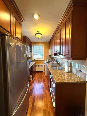 a kitchen with granite countertop stainless steel appliances a refrigerator a sink a stove and cabinets
