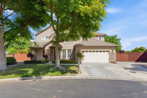 a view of a house with a yard and large tree